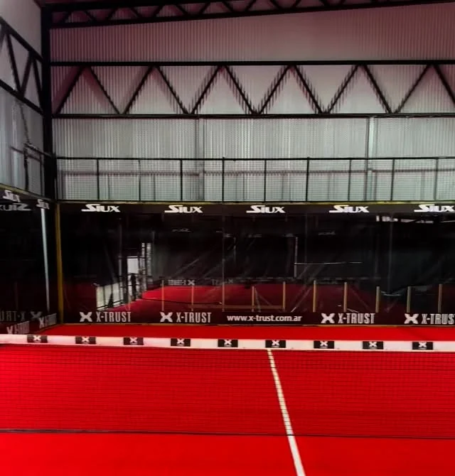 Cancha roja de WIN con red y cerramiento bajo techo