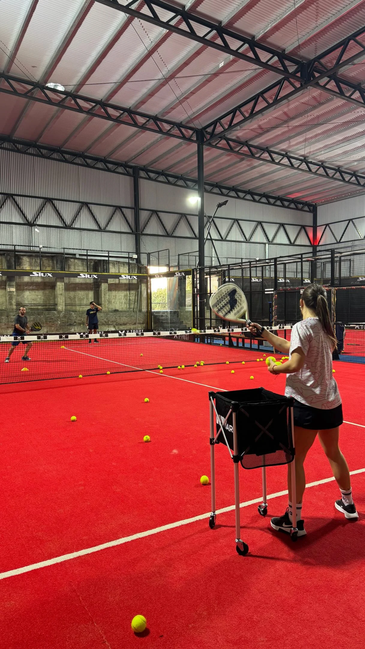 Entrenamiento de pádel en una cancha roja techada de WIN